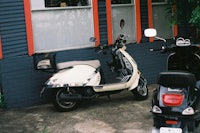 a black and white moped parked in front of a building