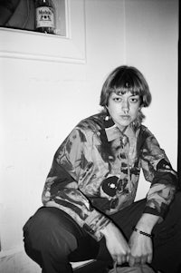 a man in a camouflage jacket sitting on the floor