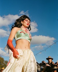 a woman in a white dress standing in front of a crowd