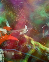 a person playing a red electric guitar