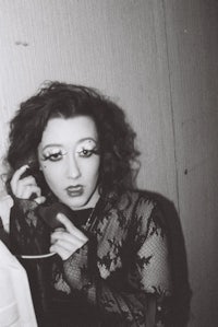 a woman in a lace dress talking on a cell phone