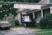 a chain link fence with a car parked in front of it