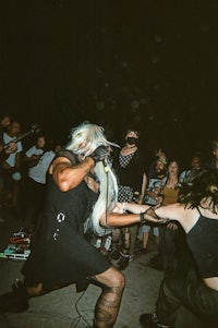 a woman in a black dress is holding a microphone