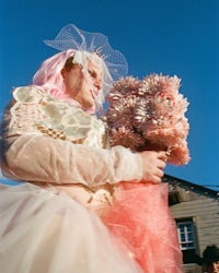 a woman in a pink tutu holding a bouquet of flowers